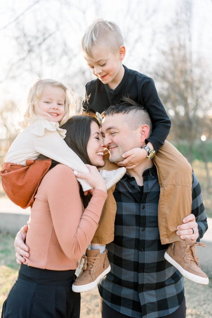 Family of four, kids on parents' shoulders