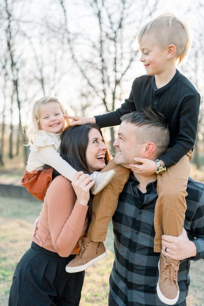 Family of four, kids on parents' shoulders