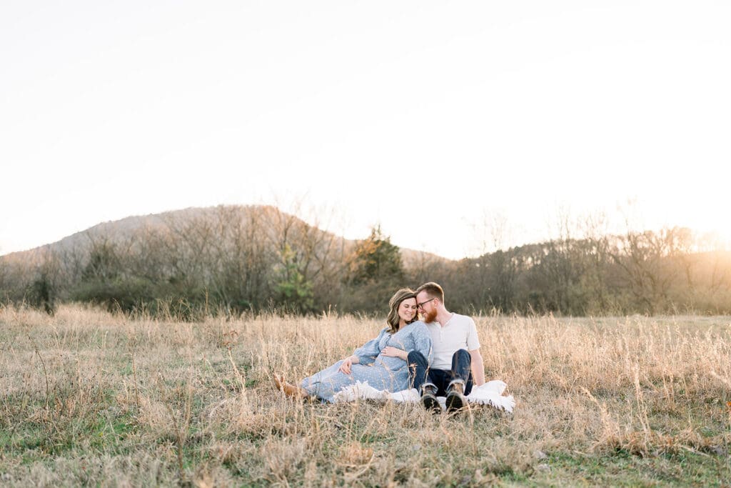 Expecting family sitting together in a field